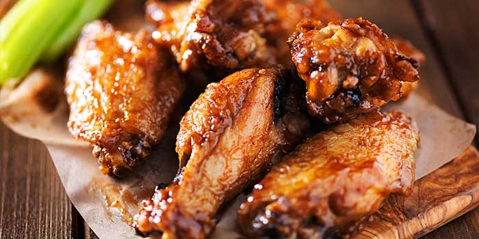 barbecue chicken wings close up on wooden tray shot 